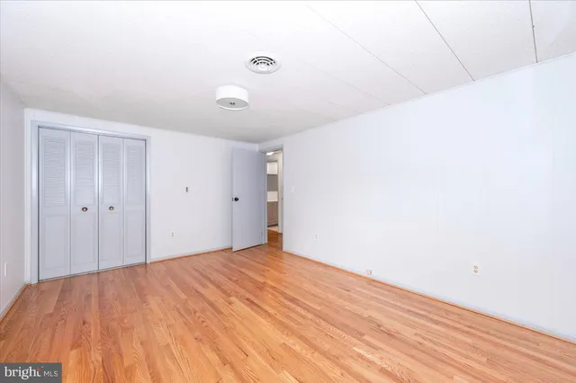 a view of empty room with wooden floor