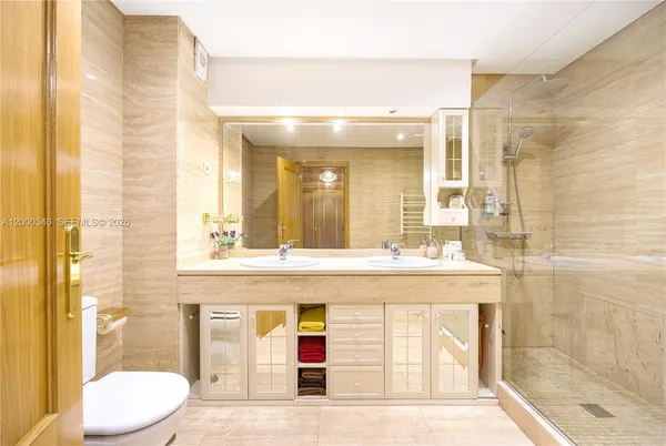 a bathroom with a granite countertop sink mirror vanity and toilet
