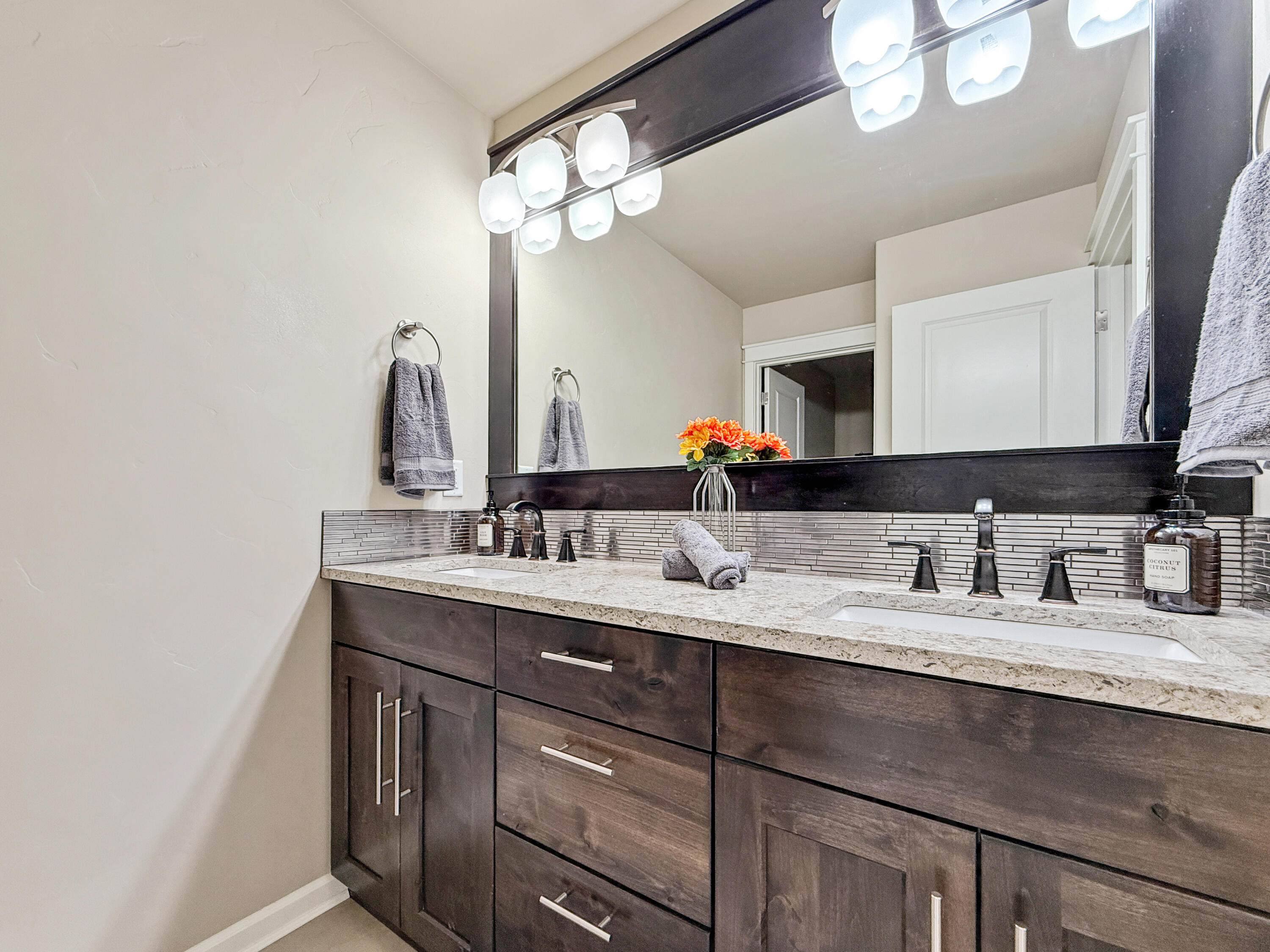 61072 Manhae Loop Bend, OR 97702 - Photo 34 of 63 a bathroom with a granite countertop sink a large mirror and vanity