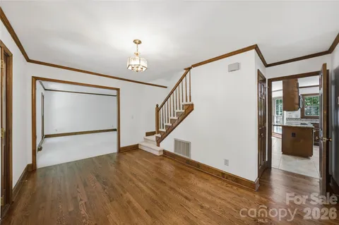 a view of an entryway with wooden floor and livingroom