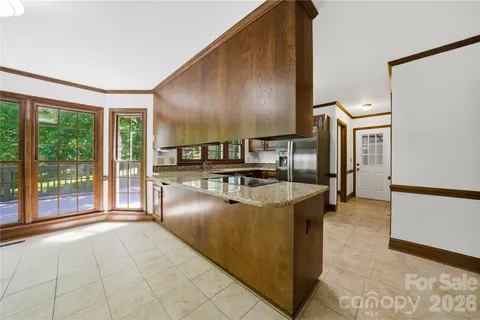 a kitchen with stainless steel appliances granite countertop a stove a refrigerator and a view of living room