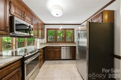 a kitchen with stainless steel appliances granite countertop a refrigerator a stove and a microwave