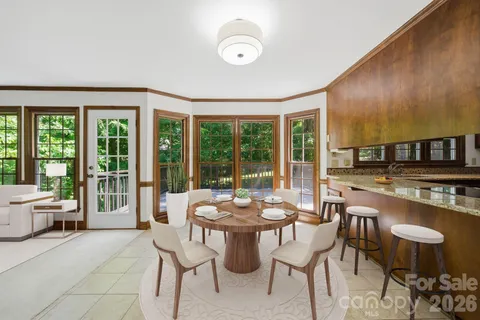 a dining room with furniture and large windows