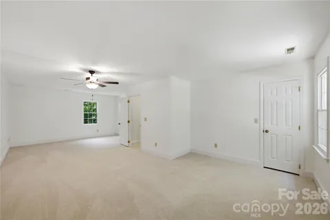 an empty room with a ceiling fan and a window