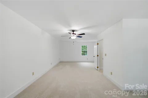 an empty room with a ceiling fan and a window