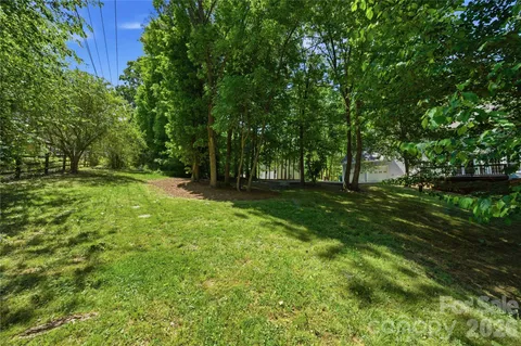 a view of green field with trees in the background