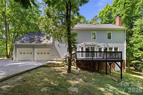 a view of a house with a wooden deck and a yard