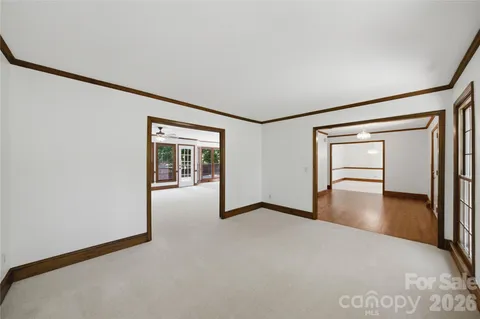 a view of a big room with wooden floor and windows
