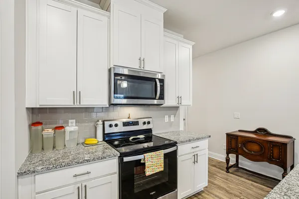a kitchen with stainless steel appliances granite countertop a stove a microwave and sink
