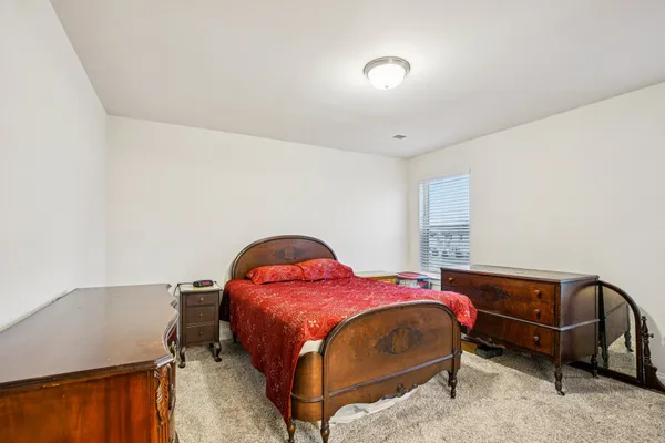 a spacious bedroom with a bed and a cabinets