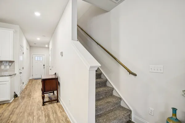a view of a hallway with wooden floor and staircase