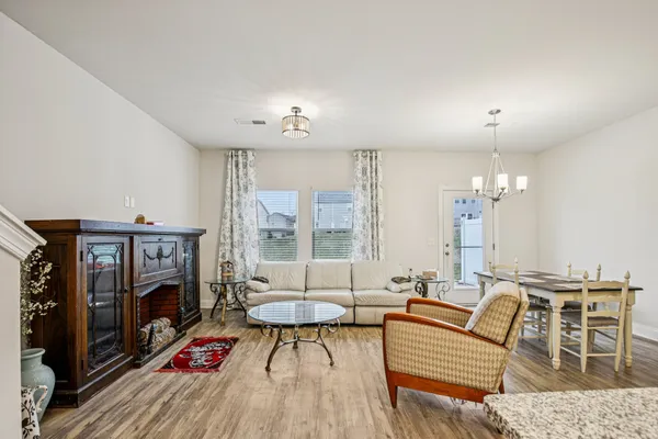 a living room with furniture a fireplace and a chandelier