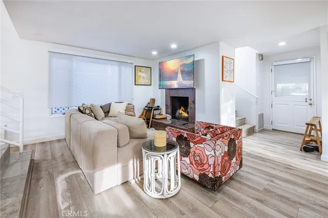 a living room with furniture fireplace and wooden floor
