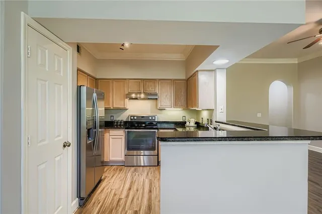 a kitchen with stainless steel appliances granite countertop a sink and a stove top oven