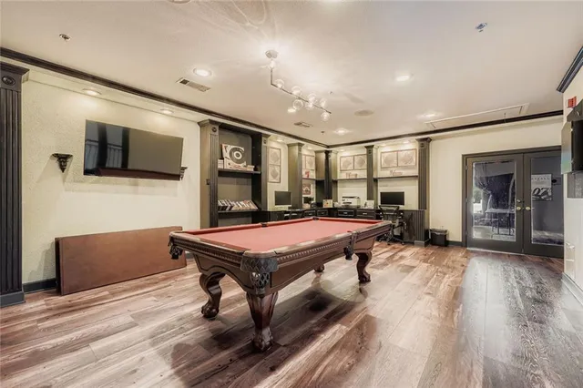 a room with furniture pool table flat screen tv and windows