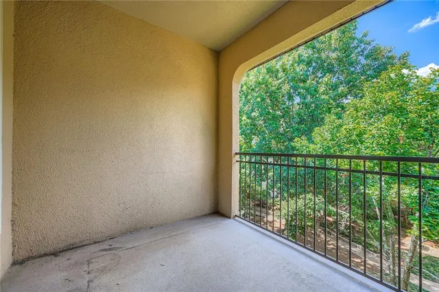 a view of balcony with floor to ceiling window plants and wooden fence