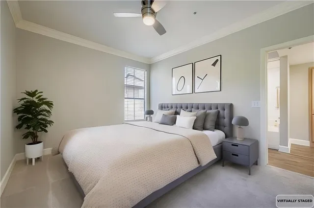 a bedroom with a large bed and a potted plant