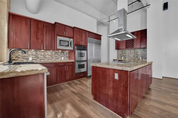 a kitchen with stainless steel appliances granite countertop wooden cabinets a oven and granite counter tops