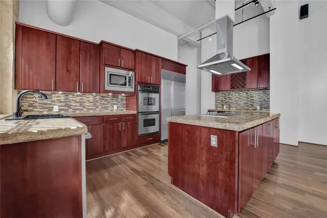 a kitchen with stainless steel appliances granite countertop wooden cabinets a oven and granite counter tops