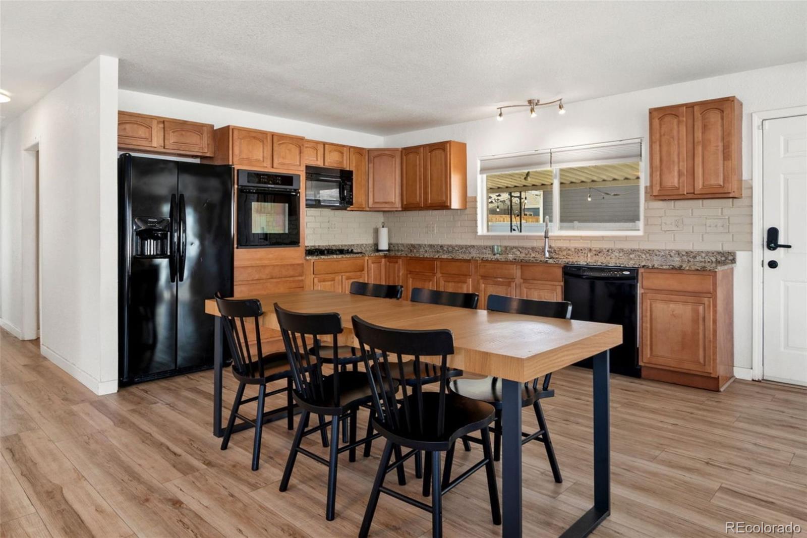 5533 Raritan Way Denver, CO 80221 - Photo 3 of 22 a dining table with chairs and wooden floor