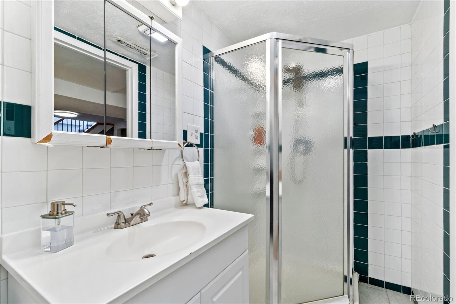 5533 Raritan Way Denver, CO 80221 - Photo 8 of 22 a bathroom with a sink shower and a mirror
