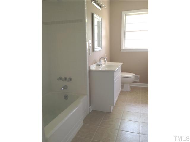 905 Powell Drive Raleigh, NC 27606 - Photo 7 of 11 Fabulous hall full bath with tile flooring, new toilet, vanity, mirror and lights, plus new surround in the tub/shower!