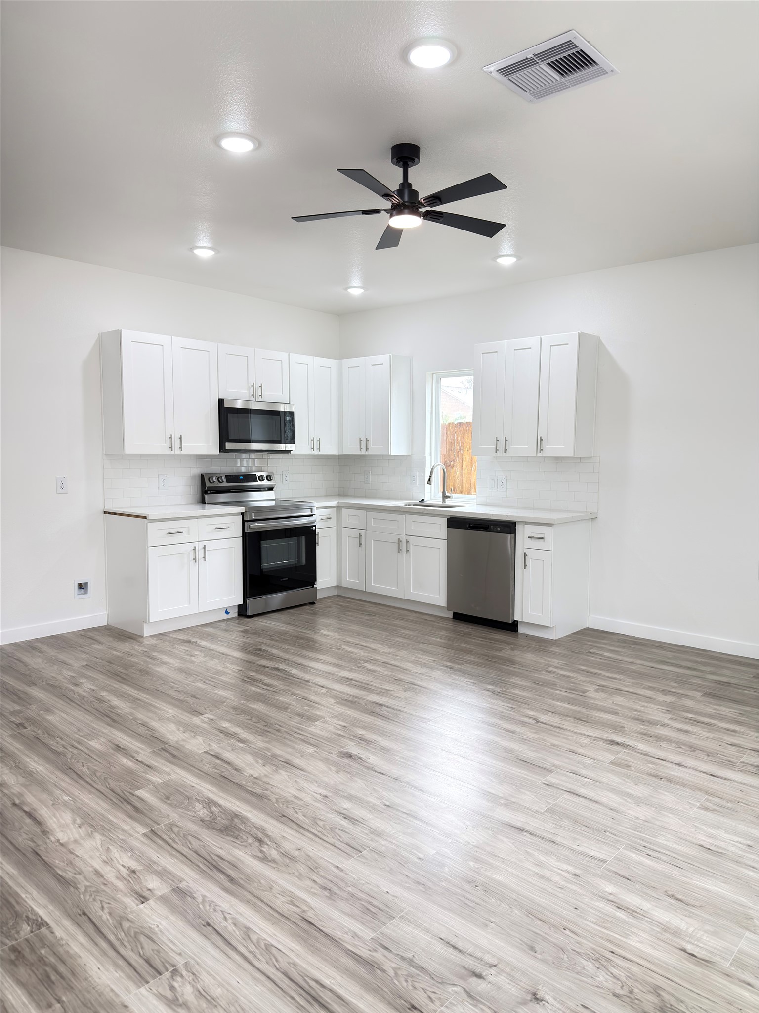 Modern open-concept kitchen seamlessly connects to the dining area, with the added convenience of a half bath on the main level.