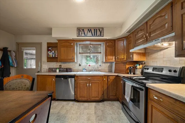 a kitchen with stainless steel appliances granite countertop a sink and stove