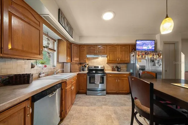 a kitchen with a stove top oven a sink dishwasher and cabinets with wooden floor