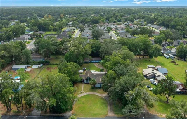 an aerial view of residential houses with outdoor space and trees