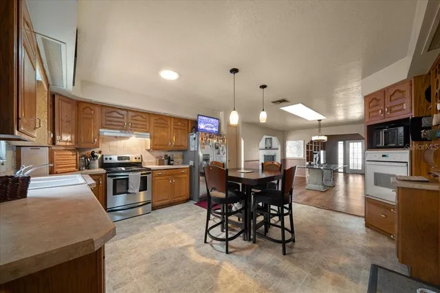 a kitchen with microwave a stove and chairs