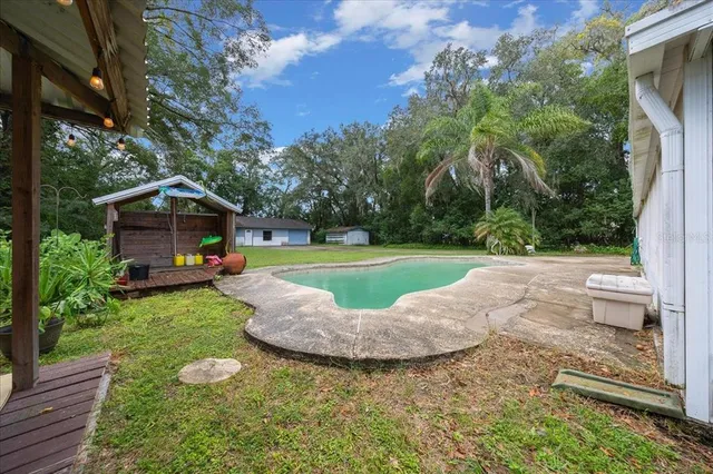 a view of a house with backyard and sitting area