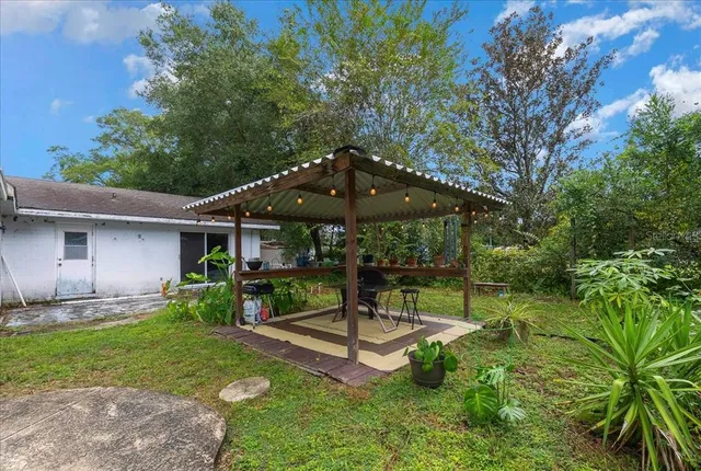 a view of a chair and table in backyard of the house