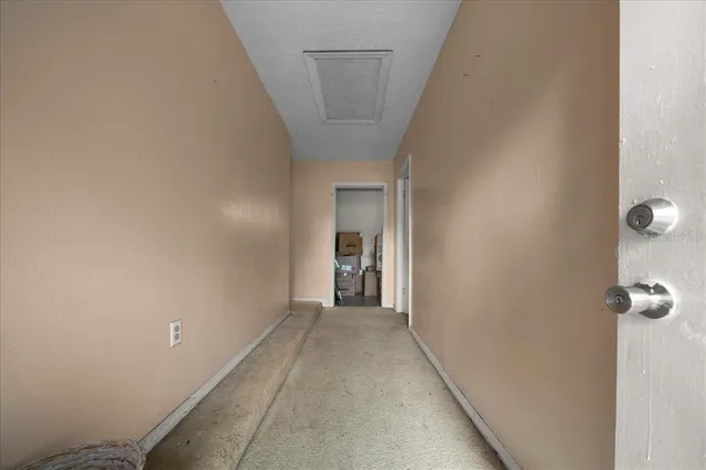 a view of a hallway with wooden floor and a bathroom