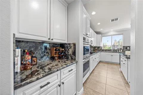 a kitchen with stainless steel appliances kitchen island granite countertop a sink and cabinets