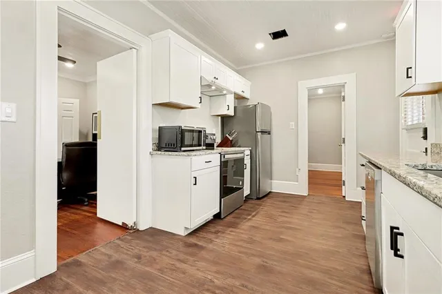 a kitchen with stainless steel appliances kitchen island granite countertop a stove and a refrigerator