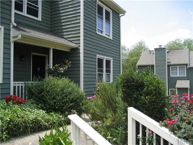 This charming townhome sits proudly on a rise, surrounded by lush plantings.