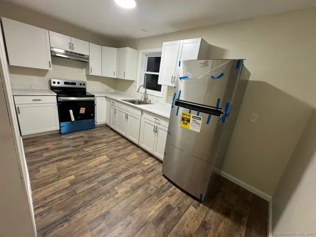 a kitchen with stainless steel appliances a refrigerator sink and cabinets