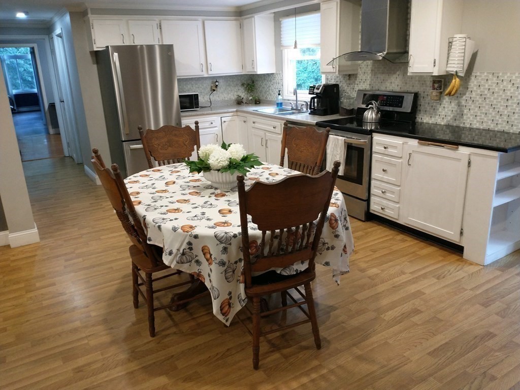 46 Apple Road Brimfield, MA 01010 - Photo 16 of 37 a kitchen with stainless steel appliances granite countertop a dining table chairs a refrigerator a stove a microwave and a refrigerator