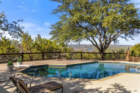 a view of a house with backyard sitting area and swimming pool