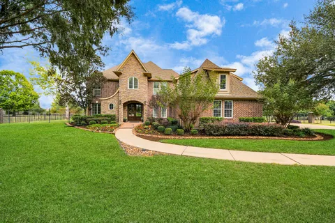 a view of a white house with a big yard and potted plants