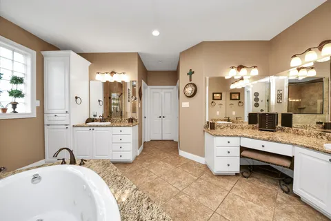 a bathroom with a granite countertop toilet a sink and a large mirror