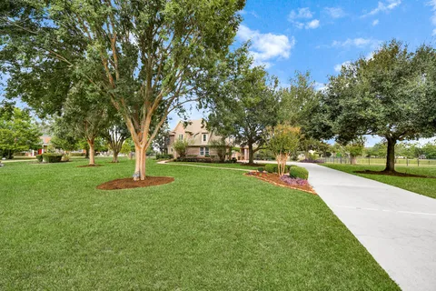 an aerial view of residential houses with outdoor space and lake view