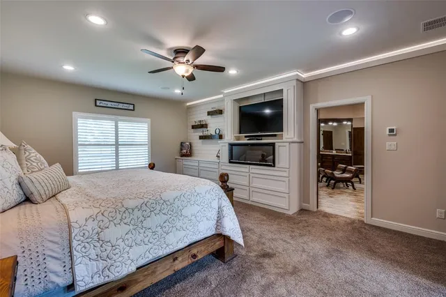 a bedroom with a large bed and a flat screen tv