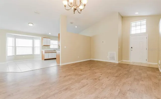 an empty room with chandelier and windows