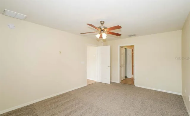 an empty room with a window and a ceiling fan