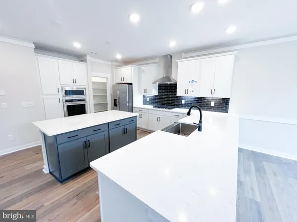 a large white kitchen with wooden floor