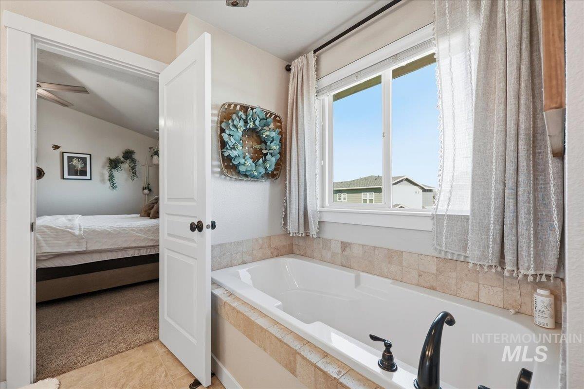 13314 Bloomfield Drive Caldwell, ID 83607 - Photo 12 of 32 Ensuite bathroom with light colored carpet, a garden tub, and lofted ceiling
