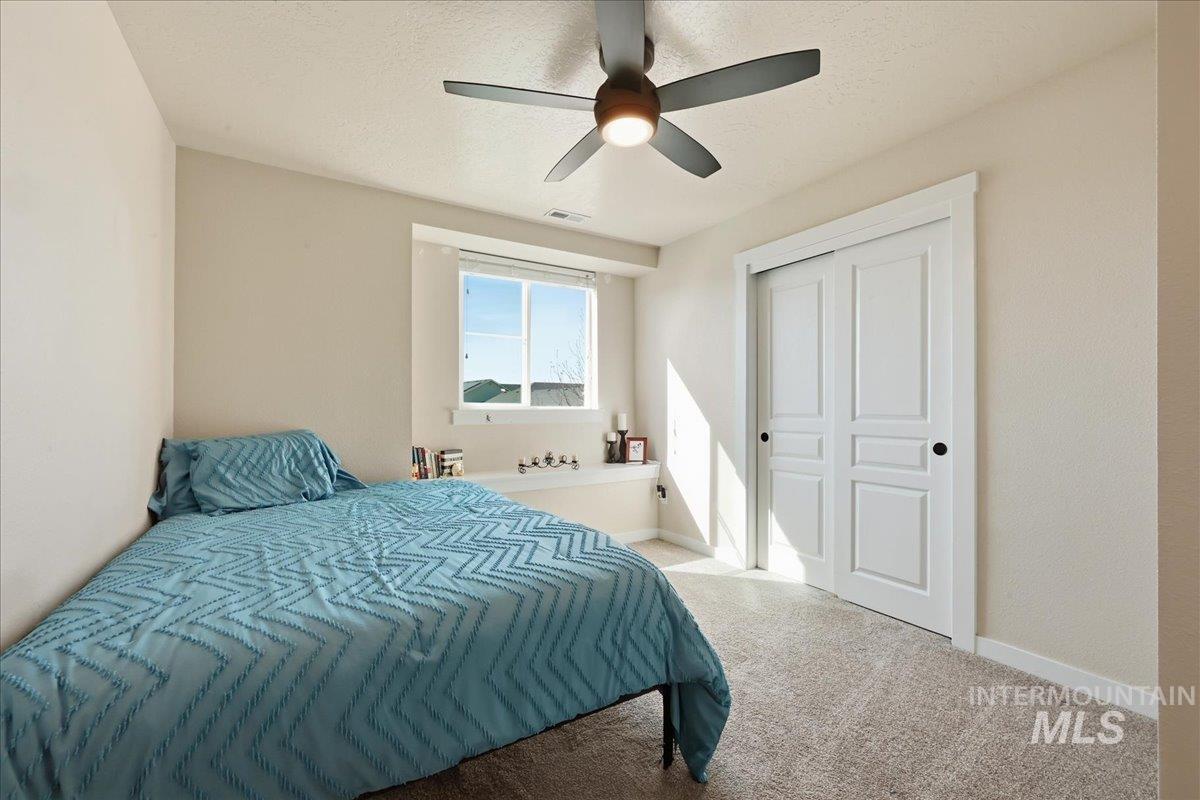 13314 Bloomfield Drive Caldwell, ID 83607 - Photo 15 of 32 Bedroom with carpet floors, ceiling fan, and a textured ceiling