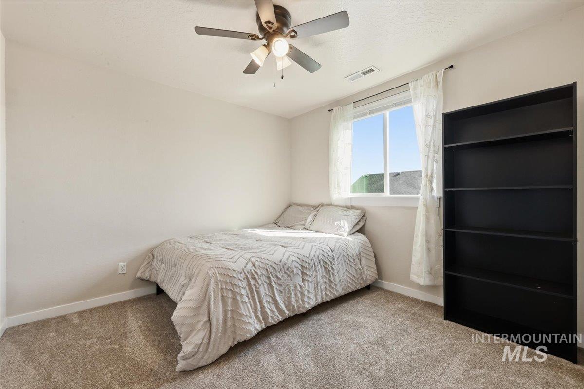13314 Bloomfield Drive Caldwell, ID 83607 - Photo 16 of 32 Bedroom featuring ceiling fan, carpet, and a textured ceiling